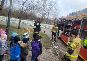 Dzieci stoją przy wozie strażackim