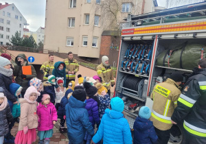 Dzieci oglądają wnętrze i zawartość sprzętu w wozie strażackim