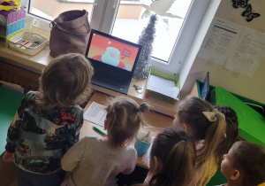Dzieci wsłuchują się w piosenkę puszczaną na laptopie o św. Mikołaju