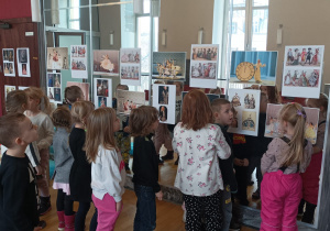 Dzieci oglądają na fotografiach stroje z teatru