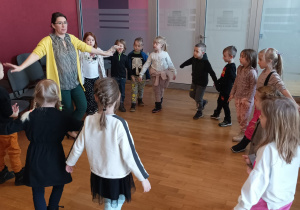 Dzieci tańczą w kole, wykonują ukłony teatralne