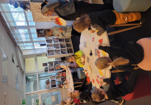 Dzieci przy stoliku intensywnie pracują - wykonują postać Czerwonego Kapturka