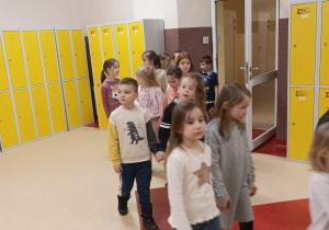 Dzieci w parach spacerują korytarzem szkoły