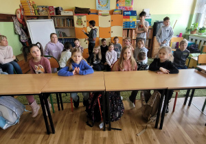 Dzieci siedzą w ławce szkolnej