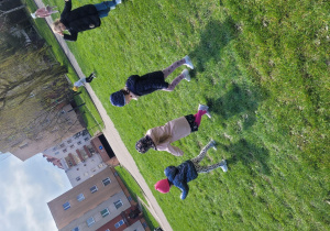 Dzieci biegają po zielonym boisku