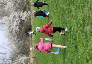 Dzieci biegają po zielonej trawie