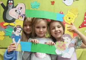 Dziewczynki pozują do zdjęcia z bajkową ramką