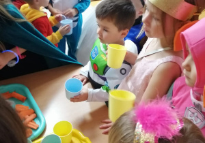 Dzieci piją wodę przy stoliku