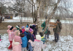 Dzieci stoją przy drzewie i słuchają ,,Wujka Kamila ''