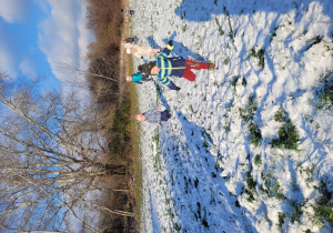 Dzieci biegają po zimowym terenie