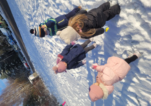 Dzieci lepią śnieżki na bałwana