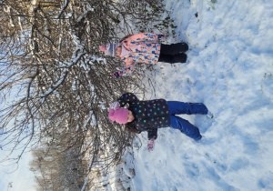 Dziewczyny pozują przy snieżnym drzewie
