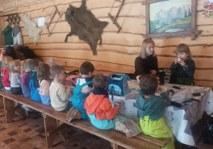 Dzieci siedzą przy stole spożywają swoje przekąski