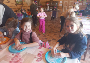 Dziewczynki siedzą przy stole formuują chlebki