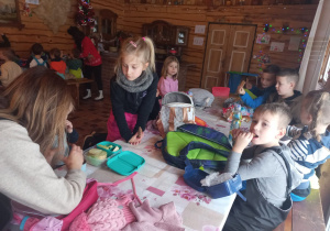 Dzieci jedzą słodkości przy stołach