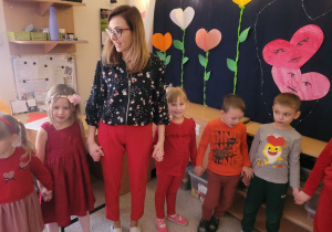 Dzieci stoją trzymają się za ręce ubrani są na czerwono