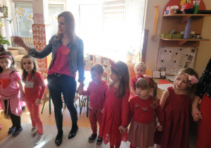 Dzieci stoją trzymają się za ręce ubrani są na czerwono