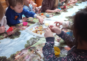 Dzieci przy stołach tworzą swoje mydełka