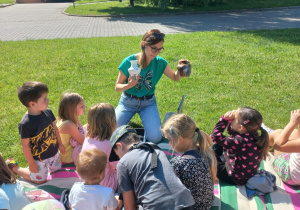 Dzieci siedza na kocach, słuchają poleceń Pani Oli