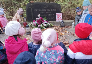 Dzieci oglądają pomnik poległych żołnierzy.
