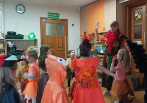 Dzieci wraz z Panią Rytmiczką tańczą podnosząc ręce do góry.