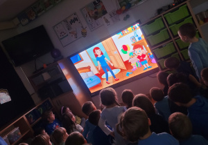 Dzieci ogladaja na monitorze interaktywnym film edukacyjny