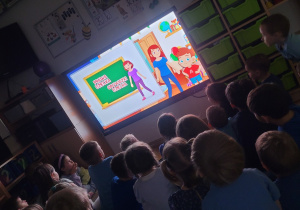 Dzieci ogladaja na monitorze interaktywnym film edukacyjny