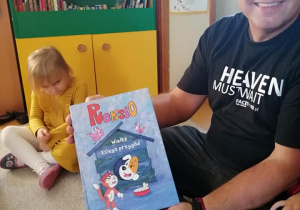 Tata Szymka prezentuje okładkę czytanej książki.