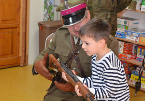 Szymon sprawdza ciężkość strzelby.