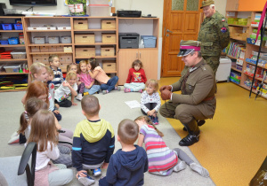 Dzieci podają sobie z rąk do rąk eksponat pistoletu