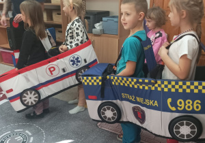 Dzieci w strojach aut - ambulansu i strazy miejskiej