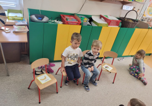 Chłopcy siedzą na krzesełkach
