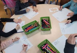 Dzieci przy stolikach rysują właściwy rysunek zgodnie z nazwą w języku angielskim