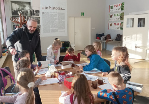 Dzieci siedzą przy stole , wykonują kartę pracy