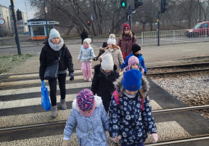 Dzieci przechodzą przez pasy na drugą stronę ulicy