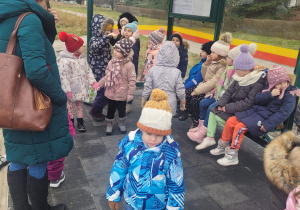 Dzieci stoją na przystanku , czekają na autobus
