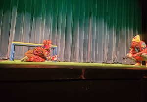 fragment spektaklu - aktorzy odgrywają role psów na przystanku tramwajowym